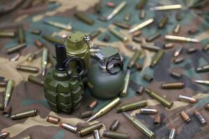 Different types of ammunition on a camouflage background. Preparing for war photo