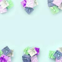 Piles of a small colored gift boxes with ribbons lies on a violet background. Minimalism flat lay top view pattern photo