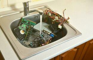 Personal computer cleaning concept. Hardware in kitchen sink photo