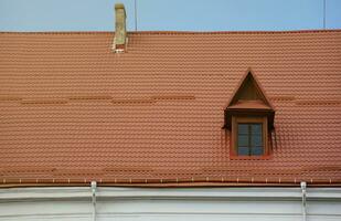 Decorative metal roof tiles in shape of old shingles. Type of roof of the house from a metal profile photo