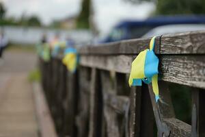 Ribbons in the colors of the national flag of Ukraine are tied to the handrail photo