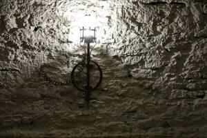 Lighted medieval castle torch hanging on a stone wall, vintage objects photo