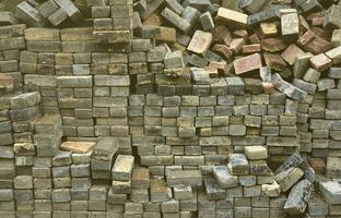 A large pile of disassembled paving slabs. A lot of square stones before the reconstruction of the pavement site photo