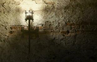 Lighted medieval castle torch hanging on a stone wall, vintage objects photo