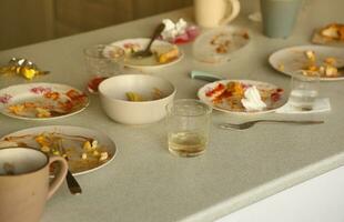 platos sucios vacíos con cucharas y tenedores en la mesa después de la comida. concepto de final de banquete. platos sin lavar foto