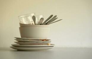 Stack of dirty dishes with food leftovers on the table after meal. Banquet ending concept. Unwashed dishes photo