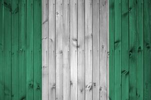 Nigeria bandera representado en brillante pintar colores en antiguo de madera pared. texturizado bandera en áspero antecedentes foto