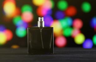 Women fragrance perfume bottle on dark festive background close up. Unnamed blank sprayer bottle of perfume photo