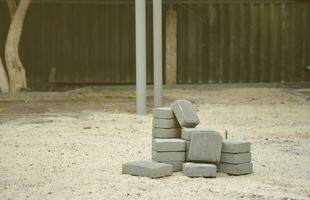 Small pile of gray walkway slabs lying in stack outdoors. Material for Paving Slabs by mosaic in progress. Cobblestone installation photo