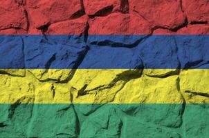 Mauritius flag depicted in paint colors on old stone wall closeup. Textured banner on rock wall background photo