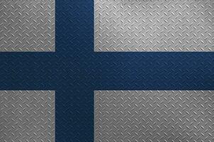 Finland flag depicted in paint colors on old brushed metal plate or wall closeup. Textured banner on rough background photo