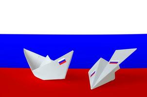 Russia flag depicted on paper origami airplane and boat. Handmade arts concept photo