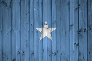 Somalia bandera representado en brillante pintar colores en antiguo de madera pared. texturizado bandera en áspero antecedentes foto