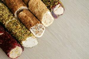 Rolls of turkish delight with many different flavors and fillings close up on table of vendors market with copy space photo