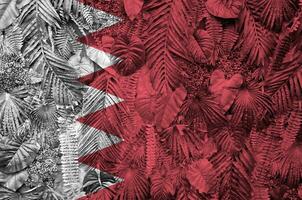 Bahrain flag depicted on many leafs of monstera palm trees. Trendy fashionable backdrop photo