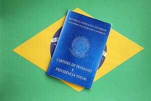 Brazilian work card and social security blue book on flag of Federative Republic of Brazil photo