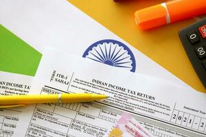 Indian income tax return blank form with pen and indian rupees bills photo