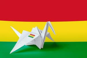 Bolivia flag depicted on paper origami crane wing. Handmade arts concept photo