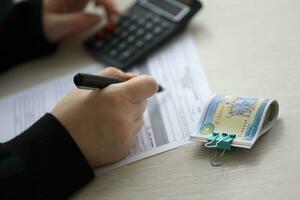 Accountant start to fill Iranian tax form on office table. Taxation period and annual taxpayers routine photo