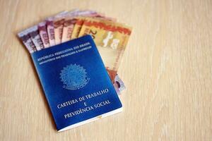 Brazilian work card and social security blue book and reais money bills photo