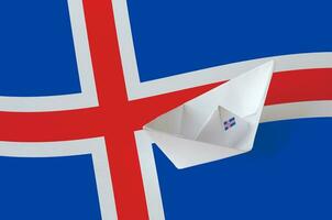 Iceland flag depicted on paper origami ship closeup. Handmade arts concept photo