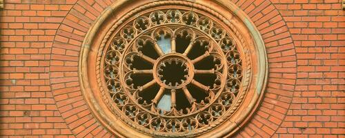 Texture front part of an ancient brick crypt with a round patterned carved window in the cemetery photo