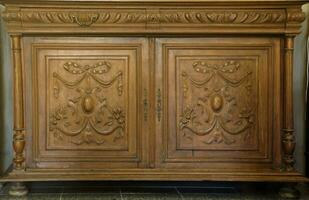 Old vintage wardrobe furniture with ornamental doors and retro colors of wooden surfaces photo