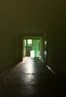 The blurred image of gloomy corridor of a neglected public building. Defocused picture of a public space in a poor residential high-rise building photo