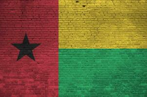 Guinea Bissau flag depicted in paint colors on old brick wall. Textured banner on big brick wall masonry background photo