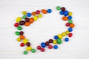 KHARKIV, UKRAINE - JANUARY 2, 2021 M and Ms colorful button shaped chocolate candies. Multi colored chocolates each of which has the letter m printed in lower case in white photo