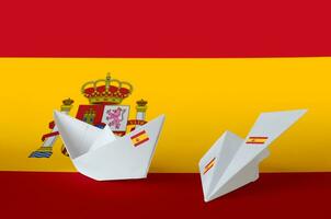 Spain flag depicted on paper origami airplane and boat. Handmade arts concept photo