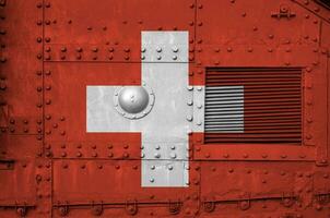 Switzerland flag depicted on side part of military armored tank closeup. Army forces conceptual background photo