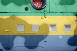 Gabon flag depicted on side part of military armored helicopter closeup. Army forces aircraft conceptual background photo