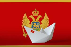 Montenegro flag depicted on paper origami ship closeup. Handmade arts concept photo