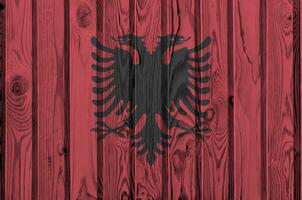 Albania bandera representado en brillante pintar colores en antiguo de madera pared. texturizado bandera en áspero antecedentes foto