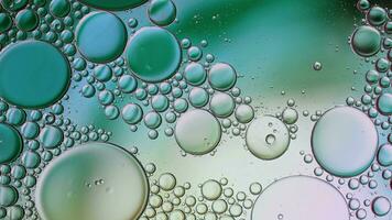 óleo de comida colorida abstrata gotas de bolhas e esferas fluindo na superfície da água video