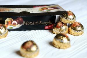 KHARKOV, UKRAINE - April 19, 2021 Henry Lambertz Mozart-Kugeln luxury dark chocolate candies in black box on white table photo