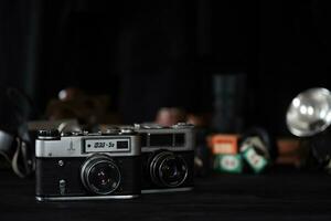 KHARKOV, UKRAINE - APRIL 27, 2021 Fed 4 and 5b Film photo camera and another old retro photo equipment on black wooden table in photographer darkroom. Photographic gear from soviet union