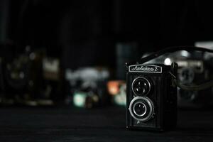 KHARKOV, UKRAINE - APRIL 27, 2021 Lubitel 166b and 2 Film photo camera and another old retro photo equipment on black wooden table in photographer darkroom. Photographic gear from soviet union