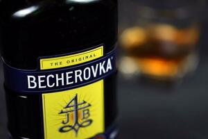 KHARKOV, UKRAINE - DECEMBER 3, 2020 Becherovka herbal liqueur bottle on dark black background. Elite alcohol photo