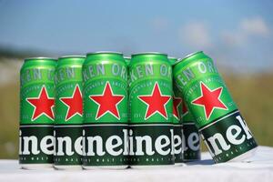 KHARKOV, UKRAINE - JULY 31, 2021 Green tin cans of Heineken lager beer produced by the Dutch brewing company Heineken N.V. photo