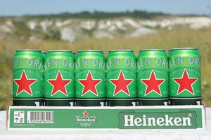 KHARKOV, UKRAINE - JULY 31, 2021 Green tin cans of Heineken lager beer produced by the Dutch brewing company Heineken N.V. photo