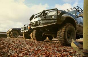 Automobile in a countryside landscape with a mud road. Off-road 4x4 suv automobile with ditry body after drive in muddy road photo