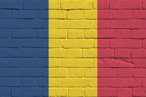 Chad flag depicted in paint colors on old brick wall. Textured banner on big brick wall masonry background photo