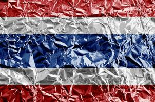 Thailand flag depicted in paint colors on shiny crumpled aluminium foil closeup. Textured banner on rough background photo