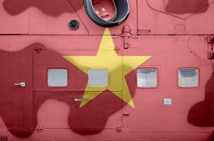 Vietnam flag depicted on side part of military armored helicopter closeup. Army forces aircraft conceptual background photo