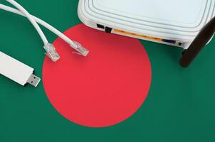 Bangladesh flag depicted on table with internet rj45 cable, wireless usb wifi adapter and router. Internet connection concept photo