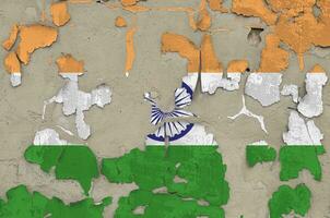 India flag depicted in paint colors on old obsolete messy concrete wall closeup. Textured banner on rough background photo