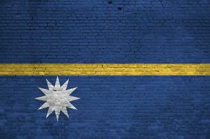 Nauru flag depicted in paint colors on old brick wall. Textured banner on big brick wall masonry background photo
