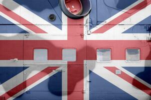 Great britain flag depicted on side part of military armored helicopter closeup. Army forces aircraft conceptual background photo